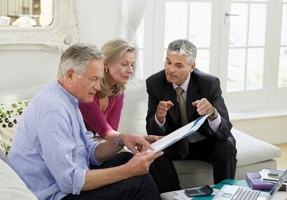 Mature couple sitting on sofa with financial advisor